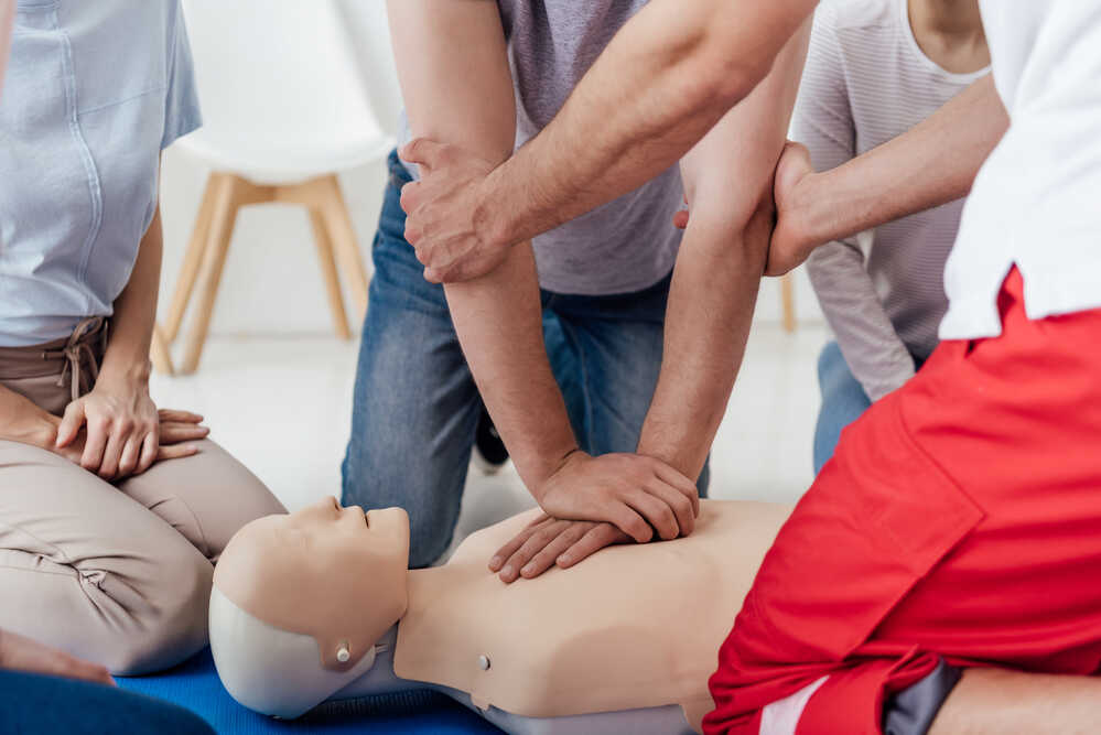 Účastníci školení první pomoci trénují masáž srdce