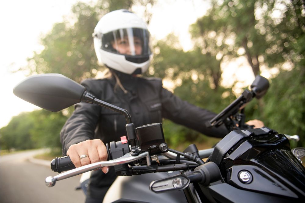 Žena si užívá jízdu na motorce po silnici