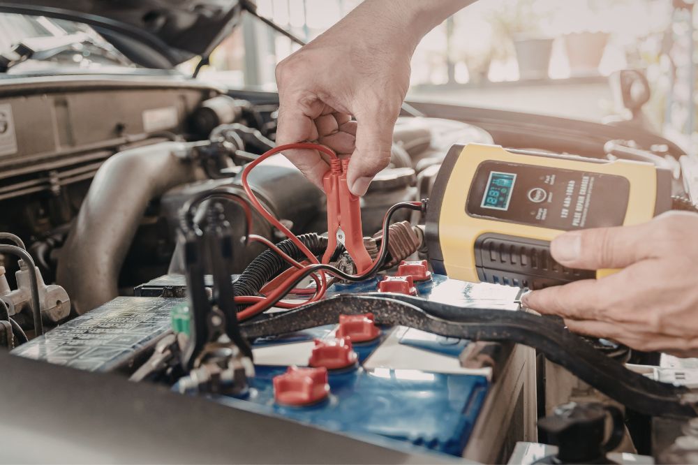 Mechanik autoservisu kontroluje napětí autobaterie