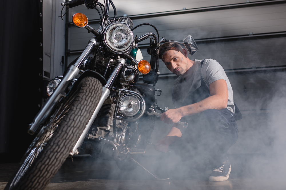 Mechanik opravující motorku v garáži