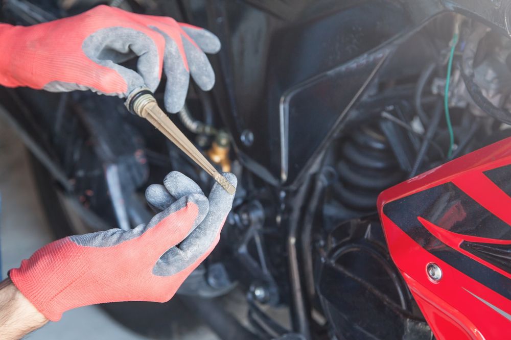 Mechanik kontroluje hladinu motorového oleje v motorce