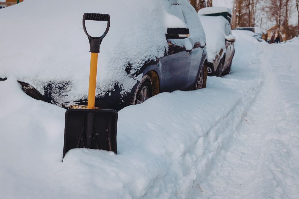 Kompaktní lopatka na sníh do auta zapíchnutá ve sněhu