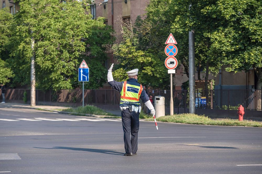 Policista na křižovatce dává řidičům pokyn