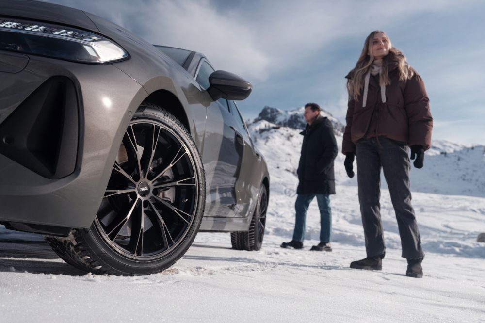 Muž a žena v hor&aacute;ch stoj&iacute; u auta s pneumatikami Nokian Tyres Snowproof 3P